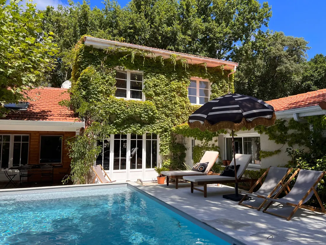 La Maison du Lac à Lacanau : la piscine devant la maison couverte de vigne vierge